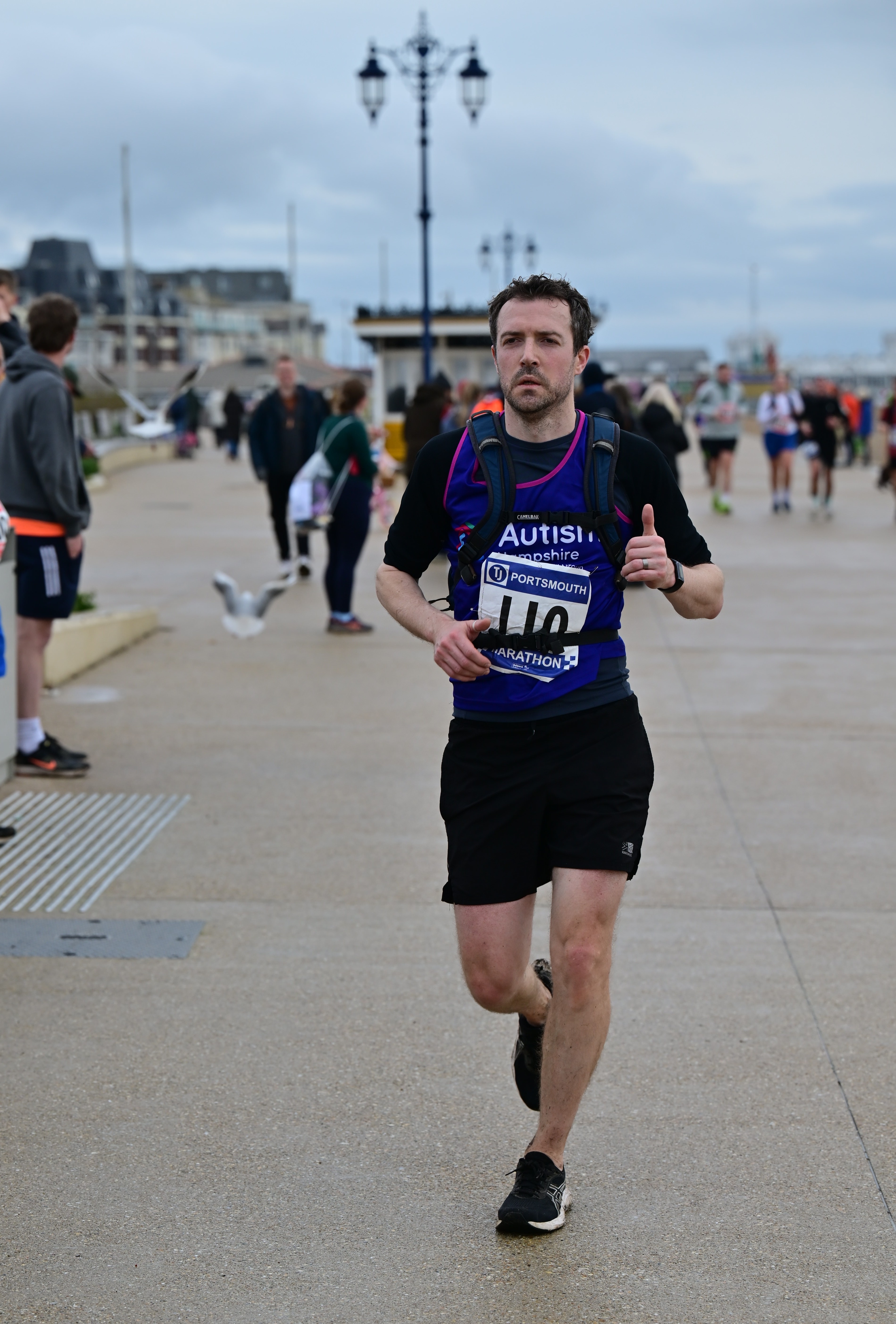 Mark runs along Portsmouth seafront wearing his Autism Hampshire running vest.