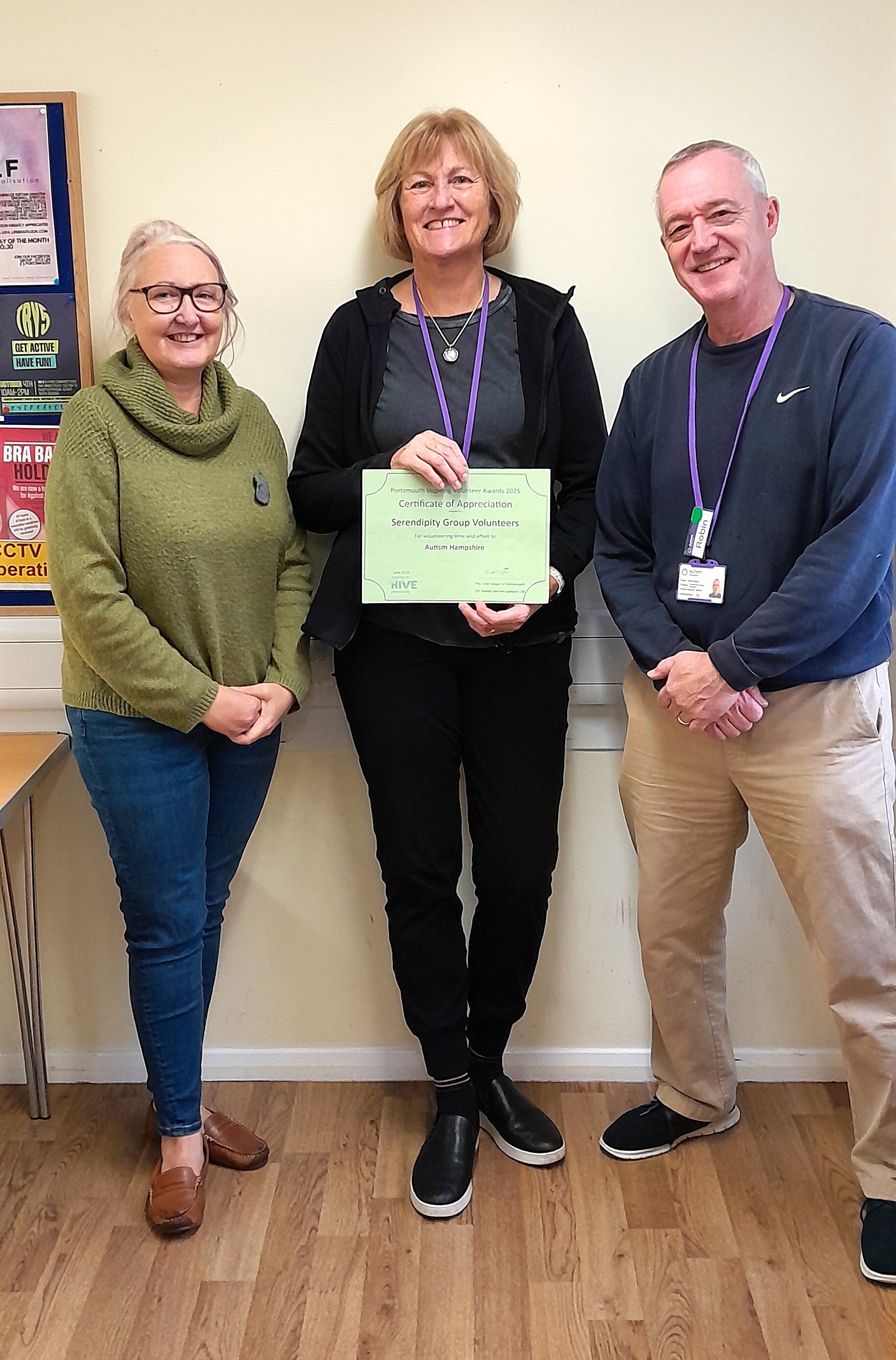 Portsmouth volunteers smile at the camera holding the certificate.