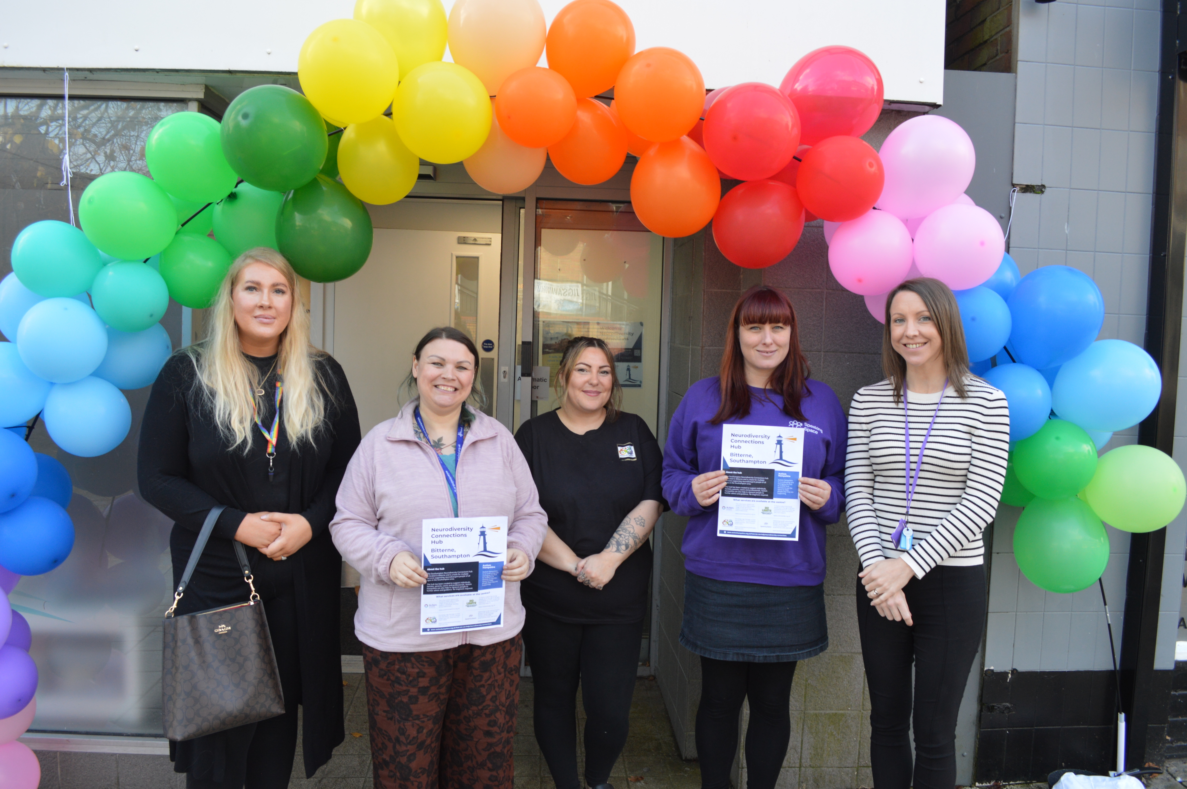 Colleagues from SASS, Solent Mind, Speaking Space and Autism Hampshire gather at the open day under a balloon arch.