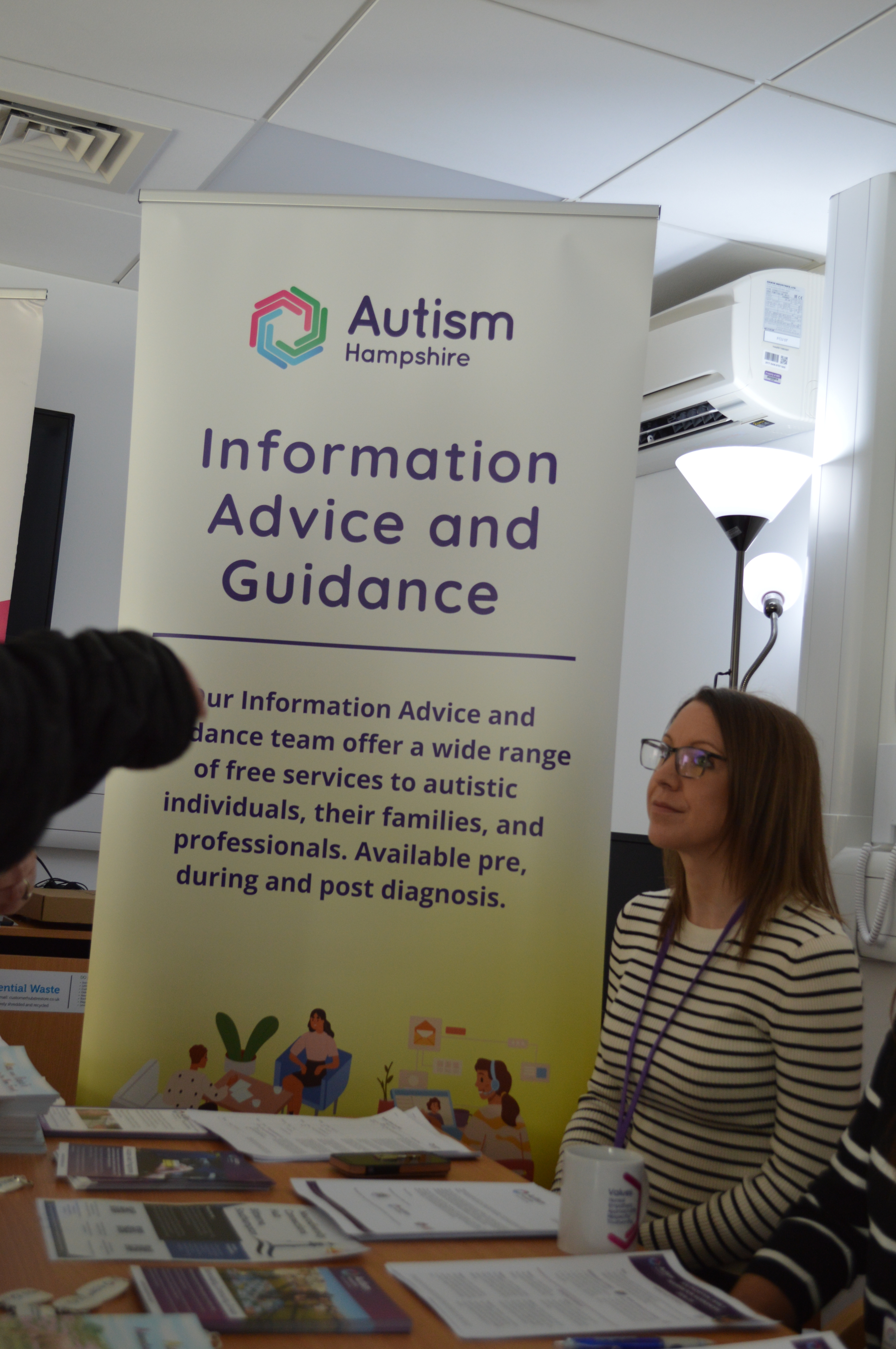 Katie Board from Autism Hampshire giving speaking to someone at the event.