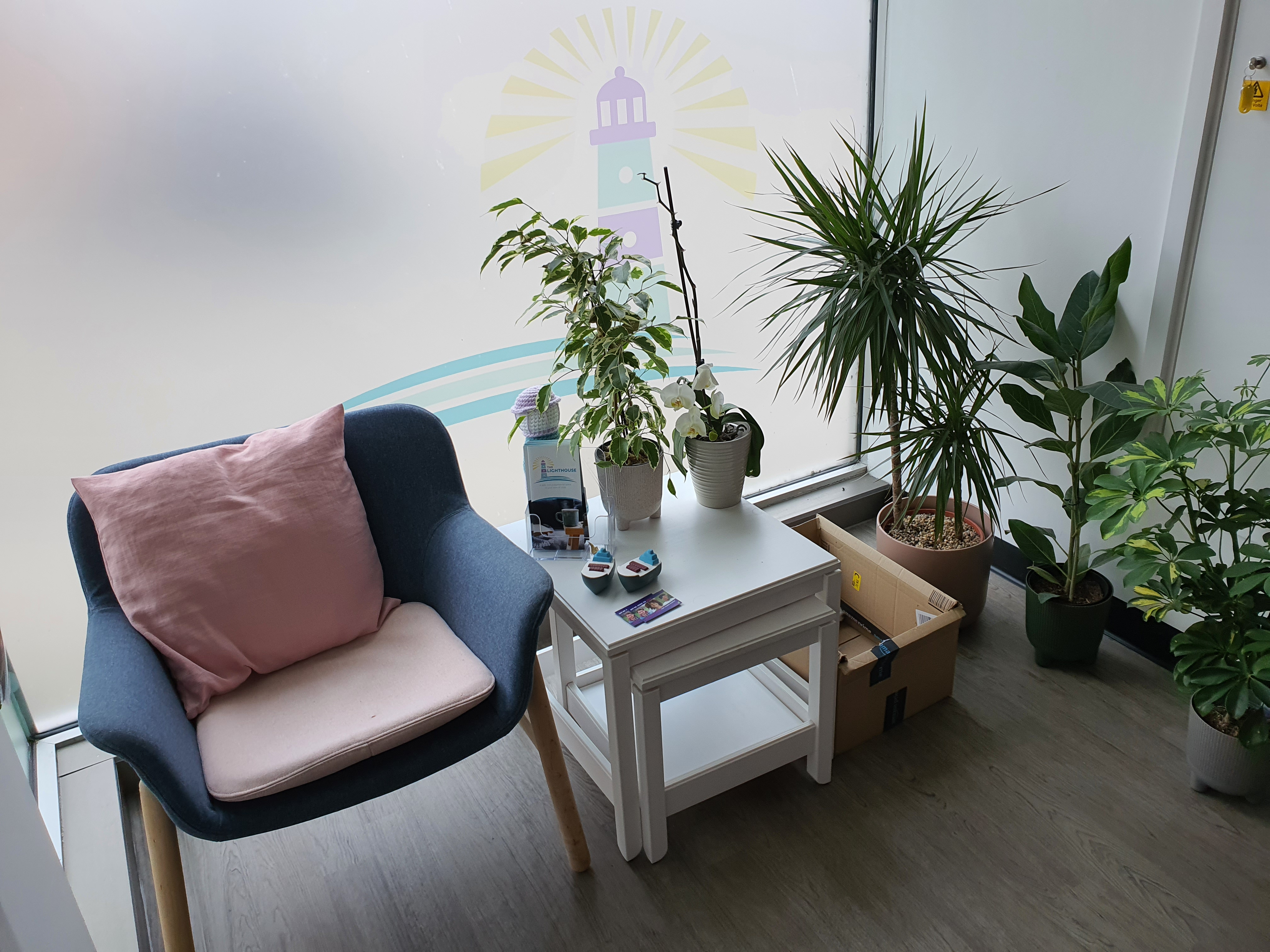 Entrance to the centre - a blue chair next to a white table surrounded by plants